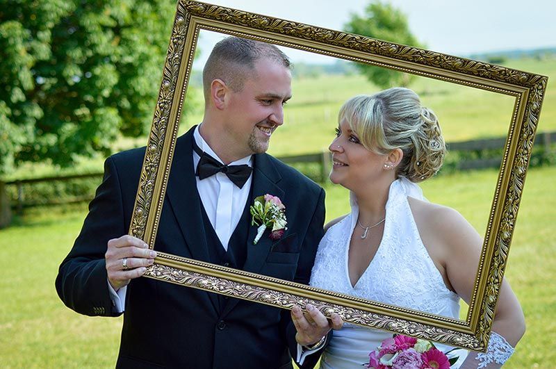 Brautpaar durch Bilderrahmen fotografiert